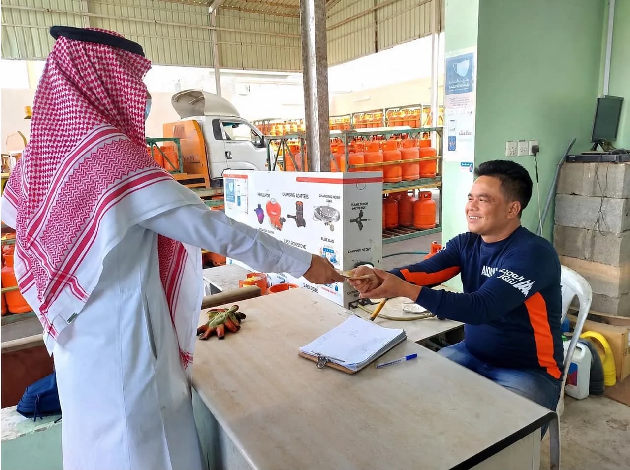 أحد العملاء يستلم أسطوانة غاز ويتم الدفع مباشرة مع الموظف